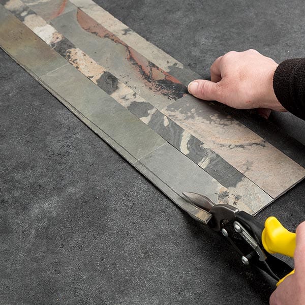 Cut the tile along the scribed line using a tin snips