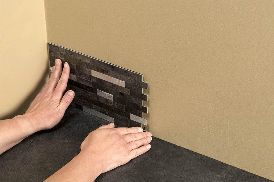 Lightly place the tile on the wall